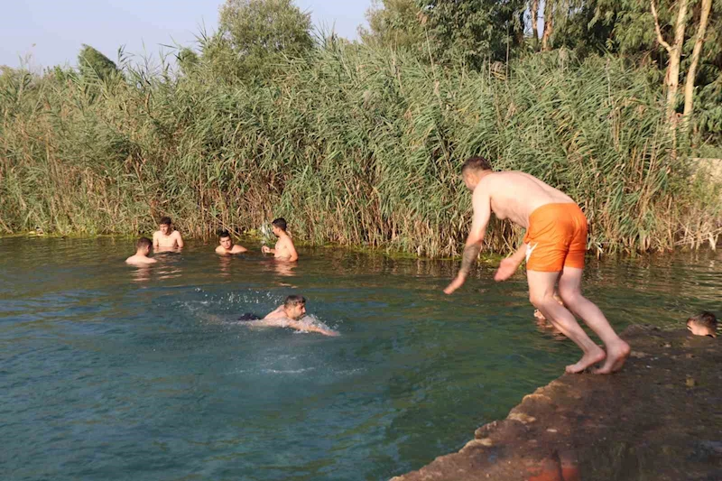 Adana’da gençler bunaltan sıcakta gölette serinledi
